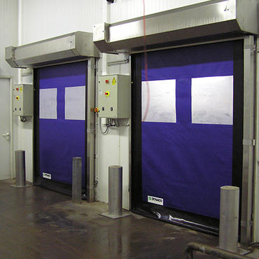 Wind resistant fabric roll up doors